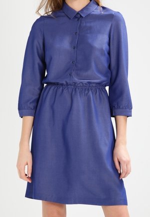 Niebieska sukienka zapinana na guziki, z kołnierzykiem, rękawami do połowy ramienia, elastycznym paskiem w talii oraz gładką, błyszczącą fakturą.
