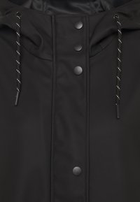 Giacca nera impermeabile con colletto alto, bottoni a pressione e cordino regolabile. Tessuto liscio con accenti di design minimalisti.