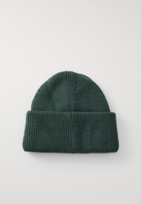 Mørk grønn strikket lue med brett. Har en ribbet tekstur og avrundet topp. Passer for kaldt vær.