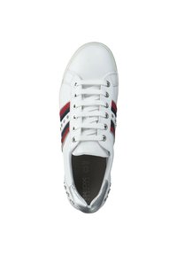Zapatilla blanca con rayas en rojo y azul marino, acento plateado en el talón y detalles con tachuelas. Diseño con cordones y punta redondeada.