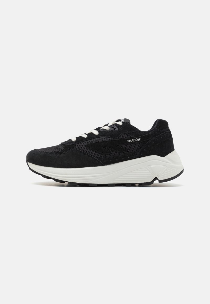 Sneakers neri con un mix di materiale scamosciato e mesh, caratterizzati da una suola intermedia bianca, suola nera e lacci di colore chiaro. Dettaglio etichetta "SHADOW".