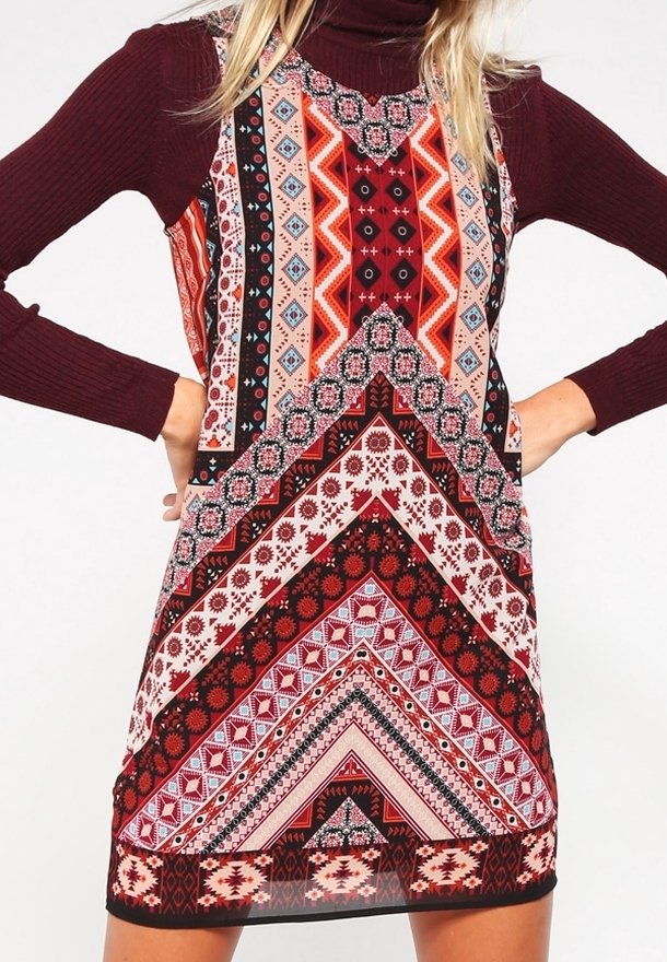 Robe multicolore présentant des motifs géométriques en rouge, noir et crème. Conçue dans un tissu léger, avec une coupe ajustée et sans manches.