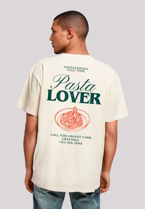 Cream-colored short-sleeve t-shirt featuring "Pasta LOVER" in green text, an orange pasta illustration, and contact details printed on the back.