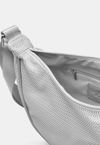 Borsa a rete grigia con un esterno texturizzato e un interno liscio. Presenta un compartimento con zip e una tracolla regolabile per un trasporto sicuro.