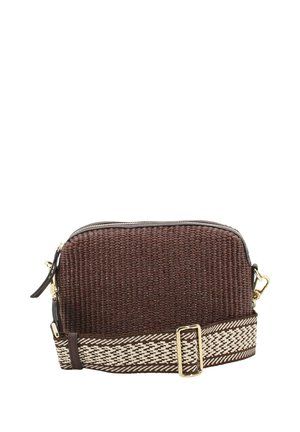 Braune gewebte Umhängetasche mit goldfarbenem Reißverschluss und verstellbarem beige-braun gemustertem Riemen, vor einem weißen Hintergrund platziert.