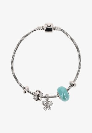 Srebrna bransoletka z zawieszką w kształcie motyla, niebieską koralikiem i trzema srebrnymi ozdobnymi koralikami na białym tle.