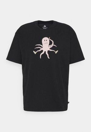 Zwart T-shirt met korte mouwen met een trieste roze octopus die gele sneakers draagt, gedrukt in het midden.