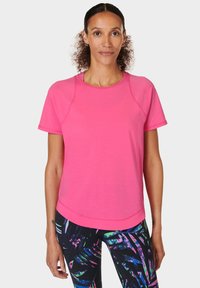 Roze sportshirt met korte mouwen en een ronde hals, gemaakt van lichtgewicht stof. Heeft raglanmouwen en een afgeronde zoom.