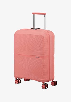 Valigia da cabina rigida rosa con linee diagonali strutturate, manico telescopico e quattro ruote doppie rotanti.