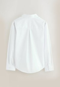 Camicia bianca a maniche lunghe con colletto, caratterizzata da un pieghettato sulla schiena, polsini con bottone e una texture liscia.