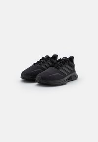 Scarpe da ginnastica nere con una tomaia in rete traspirante, dotate di tre strisce distintive, una soletta ammortizzata e una suola in gomma testurizzata.