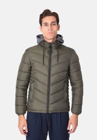 Giacca puffer verde oliva con cappuccio aderente, chiusura con zip e motivo a zigzag testurizzato; presenta polsini elastici e tasche laterali.