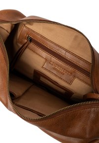 Braune Lederhandtasche mit einem Reißverschluss, die ein geräumiges Innenleben, eine Stoffauskleidung und ein internes Reißverschlussfach zur Organisation bietet.