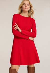 Rotes langärmliges Kleid mit tailliertem Oberteil und ausgestellt Rock. Glattes Material, Rundhalsausschnitt und keine sichtbaren Muster oder Verzierungen.