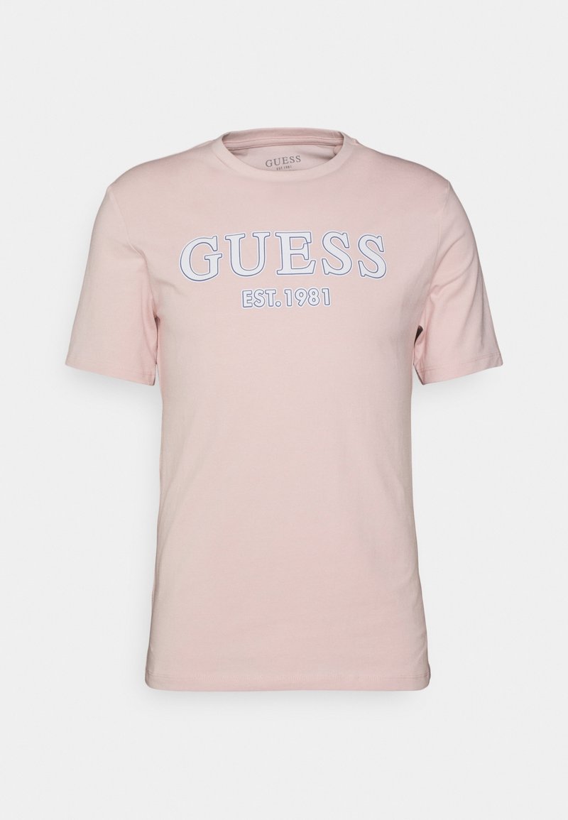 Růžová bavlněná tričko s krátkým rukávem, na přední straně s bílým logem "GUESS" a textem "EST. 1981". Kolo krk design.