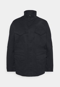 Navy blue coat featuring a high collar, four front pockets, and button details. Made of a sturdy fabric with a smooth texture.