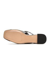 Sandal grigia con una suola morbida e testurizzata. La parte inferiore presenta una piattaforma beige con un tacco in gomma nera per una migliore aderenza. Design minimalista.