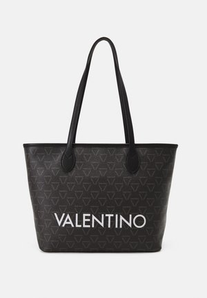 Sac cabas noir Valentino avec un motif de logo répétitif et un grand texte "VALENTINO" en blanc, comportant deux longues sangles pour l'épaule.