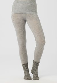 Grå leggings laget av et teksturert, elastisk materiale, kombinert med strikkede sokker i mørkegrått og hvitt med mansjett.
