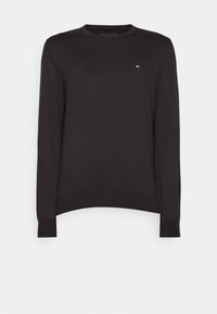 Pull noir à manches longues et col rond avec poignets et ourlet côtelés, arborant un petit logo rouge, blanc et bleu sur le côté gauche de la poitrine.