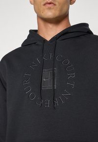 Black hoodie made of cotton blend, featuring a front logo in tonal embroidery, adjustable drawstring hood, and ribbed cuffs.