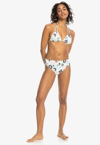 Conjunto de bikini floral que incluye un top triangular con lazos ajustables y parte inferior de tiro alto. Los colores incluyen azul, rosa y verde sobre una base blanca.