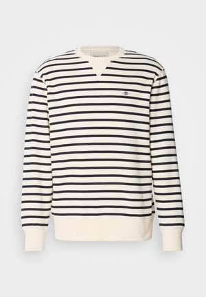 Sweatshirt à manches longues avec un design en V. Présente des rayures alternées bleu marine et crème, ainsi qu'un petit logo brodé sur la poitrine. Matière en mélange de coton.