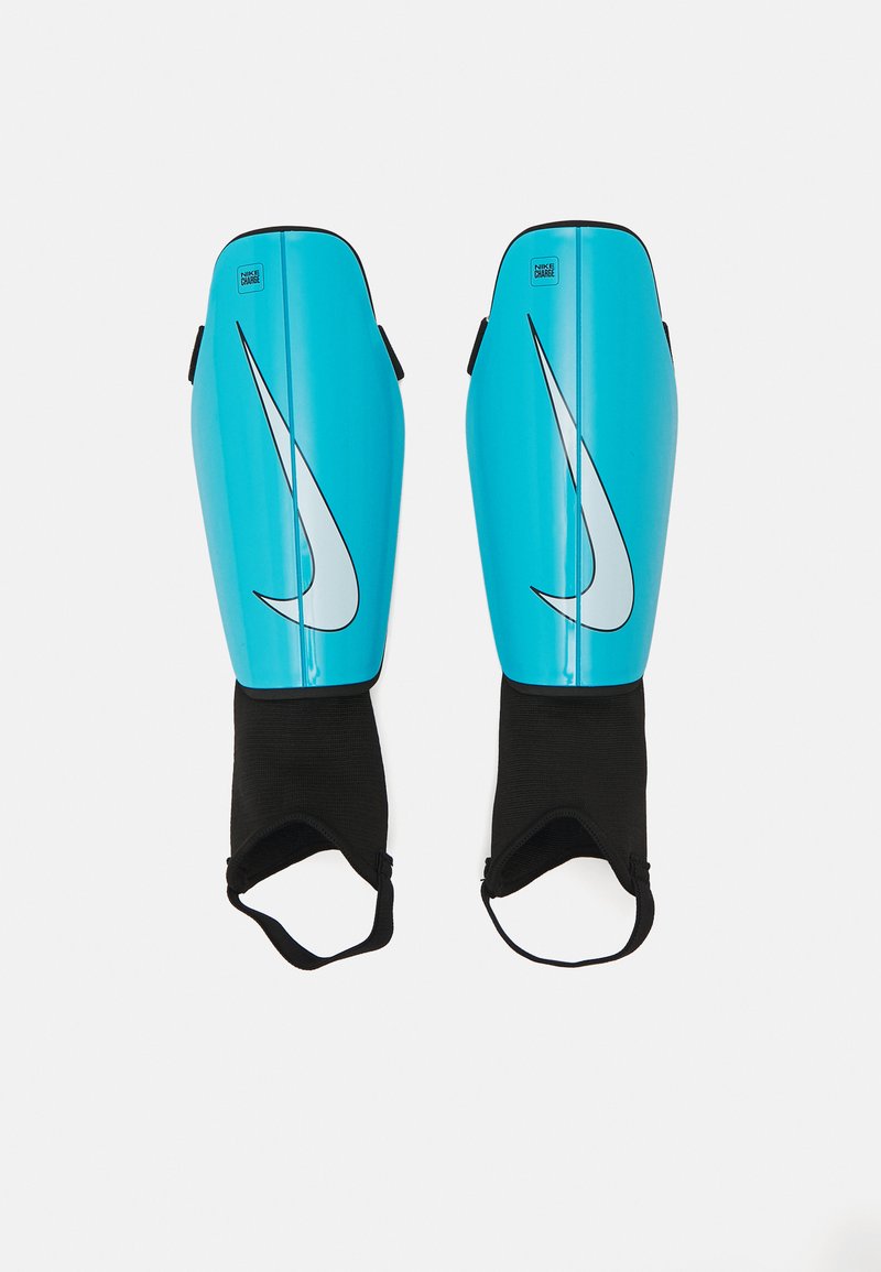Nike shin guards in vibrant blue with a large white logo. Features a lightweight plastic shell and black fabric straps for secure fitting.