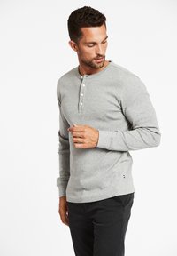 Graues Langarm-Henley-Shirt aus weicher Baumwolle, mit rundem Halsausschnitt und einer Knopfleiste mit vier Knöpfen, sowie gerippten Manschetten und Saum.
