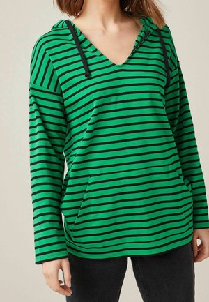 Zielona bluza z kapturem z czarnymi poziomymi paskami, czarne sznurki, przednia kieszeń, noszona przez osobę razem z czarnymi spodniami.