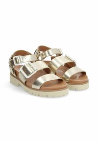 Sandales dorées métalliques avec de larges sangles, des boucles blanches et une semelle épaisse crème avec des motifs texturés. Texture en cuir lisse.