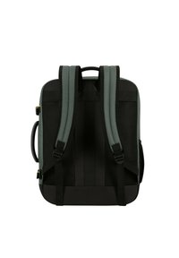 Zaino con spallacci imbottiti verdi, retro in rete nera e base nera robusta. Presenta una maniglia superiore e clip laterali regolabili.