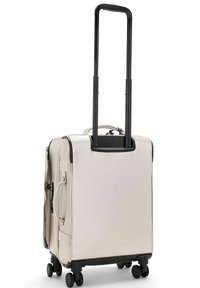 Carry-on suitcase in light beige fabric with a telescopic handle, four black wheels, and zippers, featuring side pockets and a durable design.