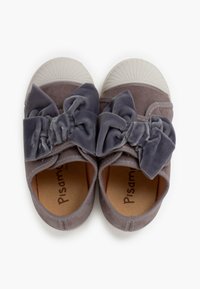 Scarpe in suede grigio con un ampio fiocco in velluto grigio sulla parte anteriore, punta in gomma bianca e rivestimento interno marrone con nome del marchio.