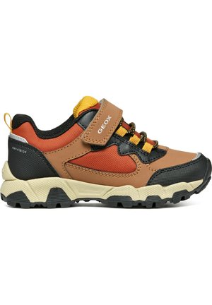 Zapatillas marrones y naranjas con acentos negros, tejido texturizado y suela duradera. Cuenta con una correa de Velcro y un diseño impermeable.
