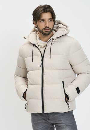 Beige geïsoleerde pufferjack met capuchon, voorzien van een zwarte rits, verstelbare trekkoorden en zijrits zakken. Glad textuur, geborduurd design.