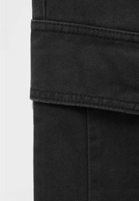Zwarte denim broek met een gestructureerde snit, contrasterende stiksels en een omgevouwen zoomdetail, dat de textuur van de stof benadrukt.