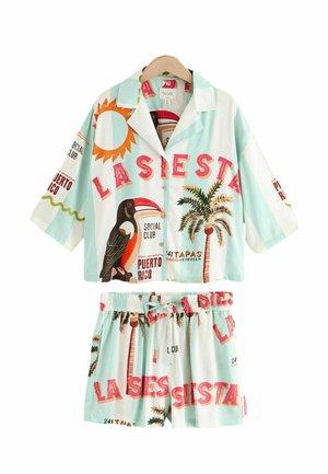 Conjunto de pijama ligero de dos piezas que incluye una camisa de botón de manga corta y pantalones cortos con cintura elástica. Predominantemente de color azul claro con estampados tropicales.