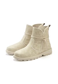 Beige Wildleder-Ankle Boots mit gewebten Designelementen, elastischen Seitenbändern, Zuglaschen und strukturierten Gummisohlen für bessere Griffigkeit und Haltbarkeit.