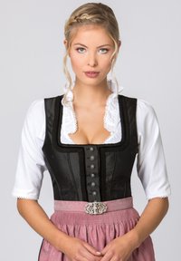 Traditionelles bayerisches Dirndl mit einem schwarzen Satin-Oberteil mit Spitzenbesatz, einer weißen Bluse und einem rosa Faltenrock mit einer dekorativen Gürtelschnalle.