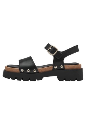 Sandalo in pelle nera con suola in gomma spessa, dettagli in legno e rivetti in argento. Presenta una fascia regolabile con una fibbia in metallo.