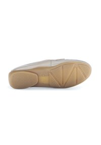 Flat shoe with a light beige upper, smooth texture, and rubber sole featuring a patterned grip. Branding visible on the sole.