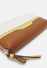 Brown and white zippered wallet, featuring a textured brown base, a smooth white top, and a yellow accent band with embossed logo.