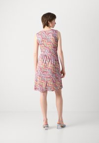 Robe sans manches arborant un motif zigzag vibrant dans des teintes de rose, jaune et bleu. Corp ajusté avec une taille élastique, jupe fluide.