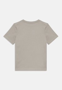 T-shirt gris à manches courtes fait en coton. Il présente un col rond et un dos uni sans graphismes ni embellissements.