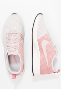 Lätta Nike löparskor i ljusrosa och vitt nätmaterial. Har en dämpad sula, snörningssystem och en rosa logotypdetalj på sidan.