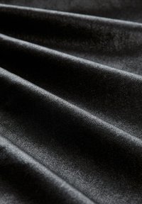 Schwarzer Stoff mit einer glatten, leicht reflektierenden Oberfläche, der mehrere elegante Falten und eine feine Textur aufweist. Das Material erscheint weich und luxuriös.