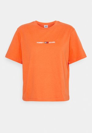 Jasnopomarańczowa koszulka z krótkim rękawem z tekstem "Tommy Jeans" i małym logo flagi w kolorach czerwonym, białym i niebieskim na środku klatki piersiowej.