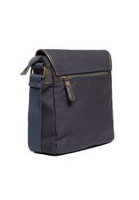 Borsa a spalla nera in tela con dettagli in pelle marrone, una tasca frontale con zip sicura e una tracolla texturizzata per una lunghezza regolabile.