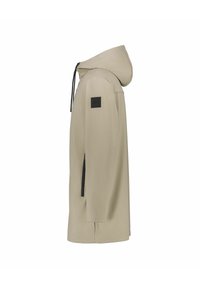 Chaqueta impermeable beige con capucha, bolsillos laterales con cremallera y un parche negro con el logo. Textura suave con un corte relajado y diseño minimalista.